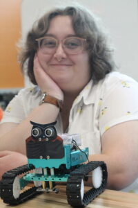 Student posing with completed vehicle